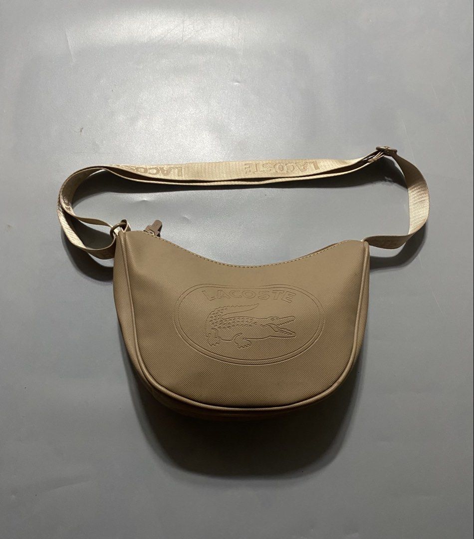 Lacoste Beige Crossbody Shoulder Bag (Category: Cross-body Bags) located in Manila. Submitted by delunakenn94368 (Listing ID 1467515704, Image 1). Description: - Authentic beige Lacoste crossbody bag made of durable textured PVC - Chic embossed crocodile logo on the front - Adjustable branded strap with distinct LACOSTE lettering - Secure top zip closure - Clean interior featuring a zip pocket and Lacoste leather patch tag - Interior tag material