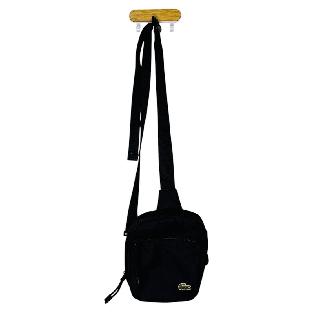 Lacoste Black Crossbody Sling Bag (Category: Sling Bags) located in Pasay City. Submitted by el.sole (Listing ID 1467530605, Image 1). Description: 👉FREE SHIPPING!!! (Within MetroManila Only) 👉FREE SHIPPING!!! (Luzon,Visayas and Mindanao) via J&T or LBC 👉Repriced: May natanggal na bilog (please see photo in red circle and arrow). See photo. But in good condition in the bag. - Brand: Lacoste - Color: Classic Black - Design: Compact crossbody ba