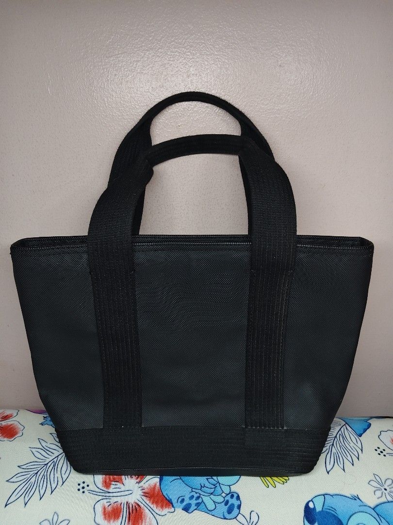 Lacoste Black leather Tote Bag with Embossed Logo (Category: Tote Bags) located in Manila. Submitted by kopishop1109 (Listing ID 1467495451, Image 2). Description: - Brand: Lacoste - Color: Black - Material: Durable canvas with light fabric interior lining - Design: Large embossed crocodile logo on the front - Straps: Double handle design for comfortable carrying - Closure: Secure zip top closure - Compartments: Spacious main compartment with an 
