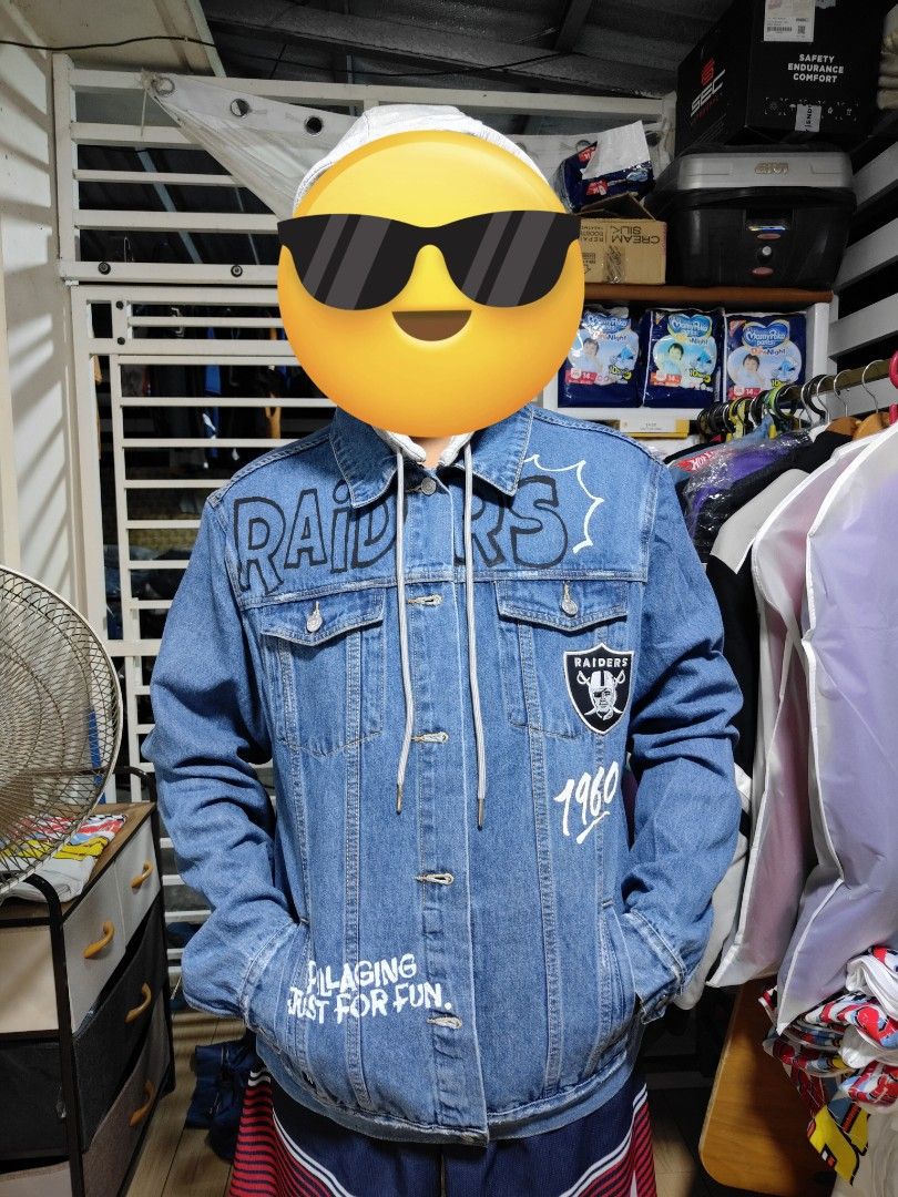 Las Vegas Raiders NFL Denim Jacket (Category: Coats, Jackets and Outerwear) located in Pandi. Submitted by yanyan_apparel.store08 (Listing ID 1467374008, Image 1). Description: - Style: Blue denim jacket with bold Las Vegas Raiders graphics - Details: Large embroidered Raiders shield patch on the back - Text Accents: Features 'The Autumn Wind', '1960', and 'Pillaging Just For Fun' - Design: Classic button-up closure - Pockets: Two chest pockets a