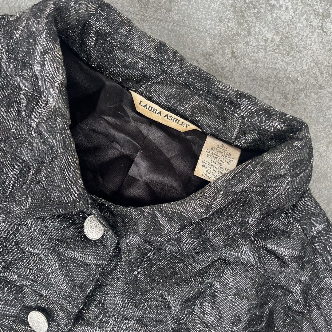 Laura Ashley Metallic Rose Jacquard Jacket (Category: Coats, Jackets and Outerwear) located in General Mariano Alvarez. Submitted by aaronatas819577 (Listing ID 1467396346, Image 3). Description: - Brand: Laura Ashley - Size: Large - Color: Metallic Black - Material: Shell (65% rayon, 29% polyester, 6% metallic), Lining (100% polyester) - Design: Textured rose pattern throughout with front pockets and silver-toned buttons - Details: Fully lined i