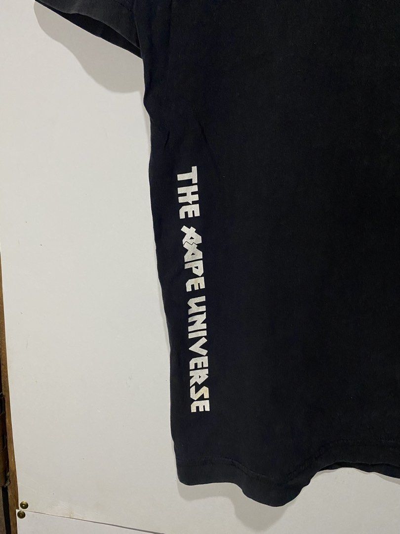 LEGIT AAPE TSHIRT (Category: Tshirts & Polo Shirts ) located in Jaen. Submitted by oshimamark58418 (Listing ID 1467539098, Image 3). Description: - Brand: AAPE by A Bathing Ape (Legit) - Color: Black - Size: Large (US 42 / EU 52) - Condition: 7/10 (shows natural vintage wear/fading and slight mark on front logo) - Design: Iconic Aape Now logo on chest, 'The Aape Universe' text on side, and bold graphic prints on the back - Fit: Comfortable cotton