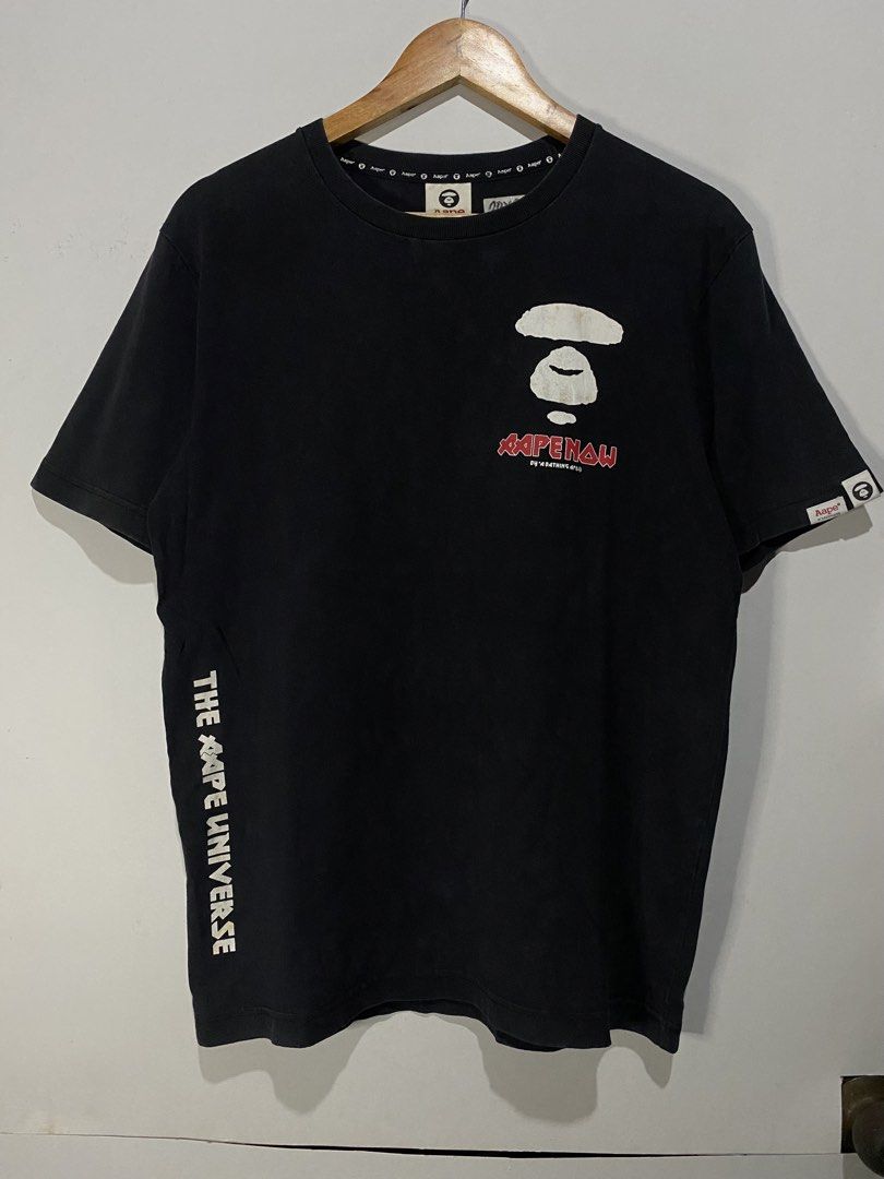LEGIT AAPE TSHIRT (Category: Tshirts & Polo Shirts ) located in Jaen. Submitted by oshimamark58418 (Listing ID 1467539098, Image 2). Description: - Brand: AAPE by A Bathing Ape (Legit) - Color: Black - Size: Large (US 42 / EU 52) - Condition: 7/10 (shows natural vintage wear/fading and slight mark on front logo) - Design: Iconic Aape Now logo on chest, 'The Aape Universe' text on side, and bold graphic prints on the back - Fit: Comfortable cotton