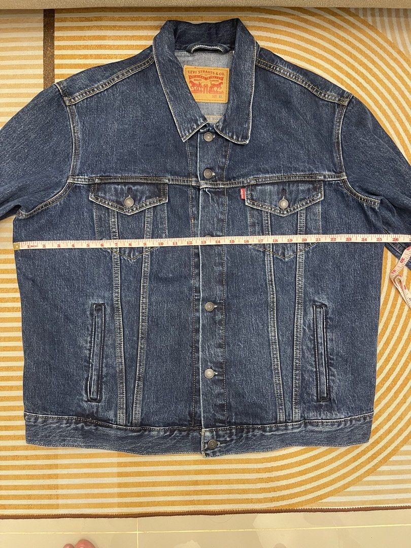 Levi's Denim Trucker Jacket Size XL (Category: Coats, Jackets and Outerwear) located in San Fernando. Submitted by bondocmac42825 (Listing ID 1467500187, Image 2). Description: - Brand: Levi Strauss & Co. - Style: Classic denim jacket in dark wash - Size: XL - Details: Metal button closures, dual chest pockets with flaps, side welt pockets, signature red tab - Origin: Made in Bangladesh - Condition: Great layering piece, versatile wardrobe staple