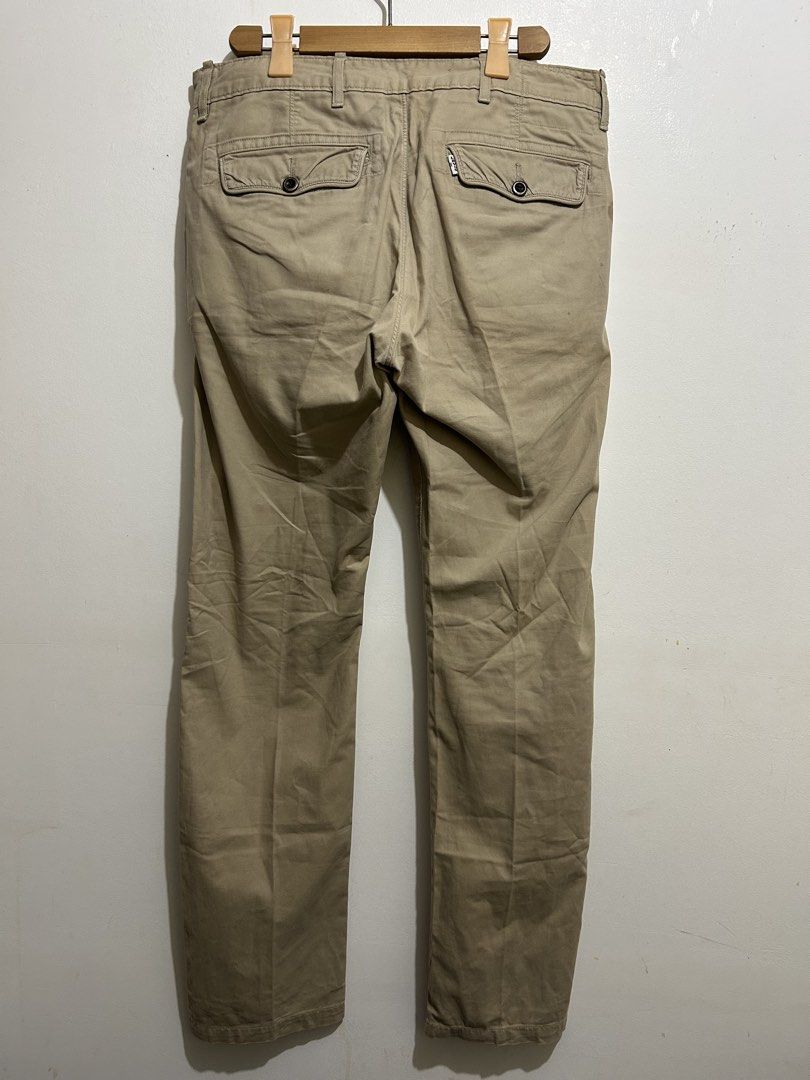 Levi's Khaki Chino Pants Button Fly (Category: Chinos) located in Calbayog City. Submitted by thrift.bucks101 (Listing ID 1467382521, Image 2). Description: - Brand: Levi's - Color: Classic tan / khaki - Material: Sturdy and comfortable cotton twill - Closure: Button fly with branded dark buttons - Pockets: Two back welt pockets with secure button flaps - Details: Signature branded red tab on the back pocket - Condition: Excellent / Ready to wear
