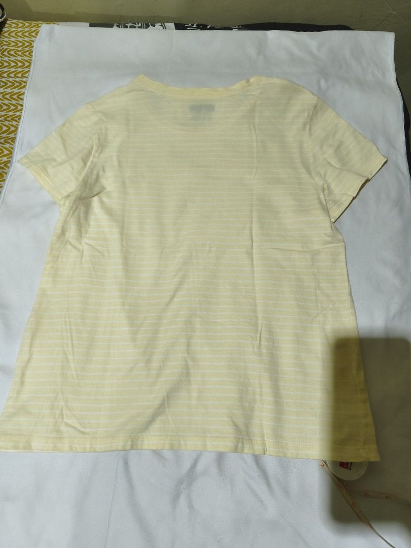Levi's Yellow Striped T-Shirt (Category: Shirts) located in Quezon City. Submitted by tintinarms (Listing ID 1467521884, Image 3). Description: - Brand: Levi's - Style: Short sleeve crew neck tee with all-over white stripes - Color: Light yellow - Size: Medium (Made in Bangladesh) - Measurement: ~18 inches pit to pit (flat lay) - Details: Small red Levi's logo patch on the chest, soft and clean cotton fabric - Condition: Great casual basic for ev