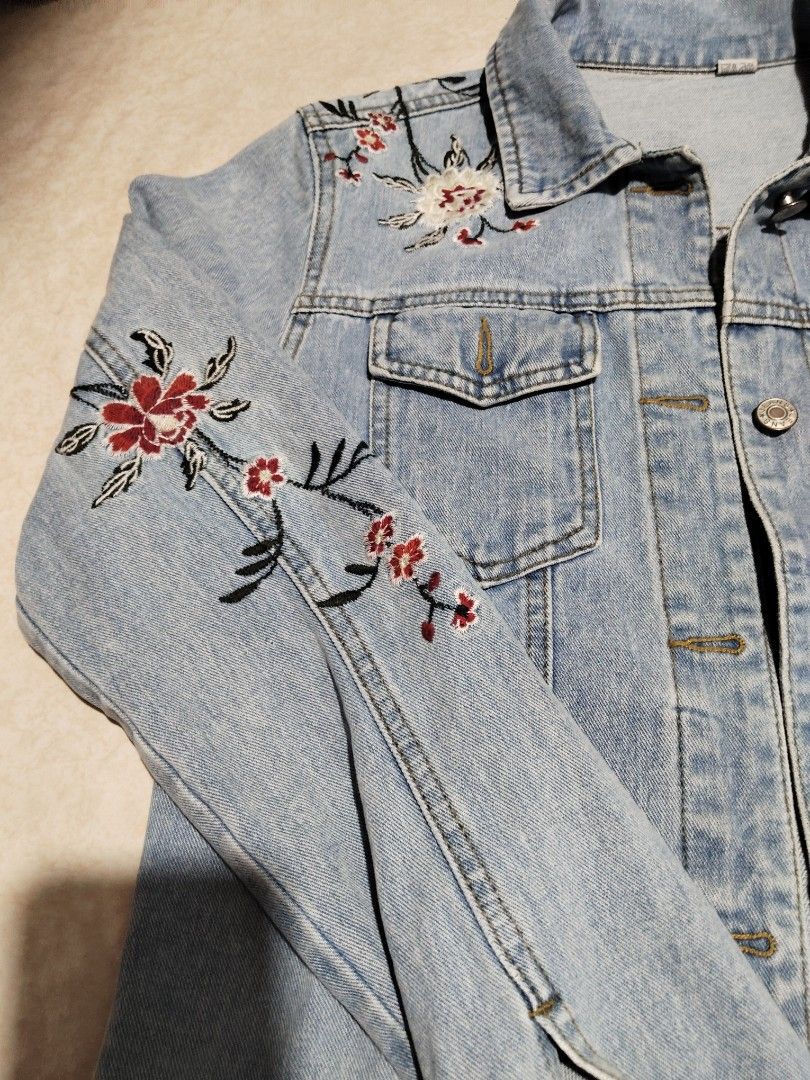 Light wash floral embroidered denim jacket (Category: Coats, Jackets and Outerwear) located in Manila. Submitted by az272019 (Listing ID 1467602855, Image 3). Description: - Style: Classic denim trucker jacket in a light wash blue - Design: Beautiful intricate floral embroidery on the chest, sleeves, and back - Details: Button-up front, collar, chest pockets, and detailed stitching throughout - Versatility: Great layering piece for cooler weather