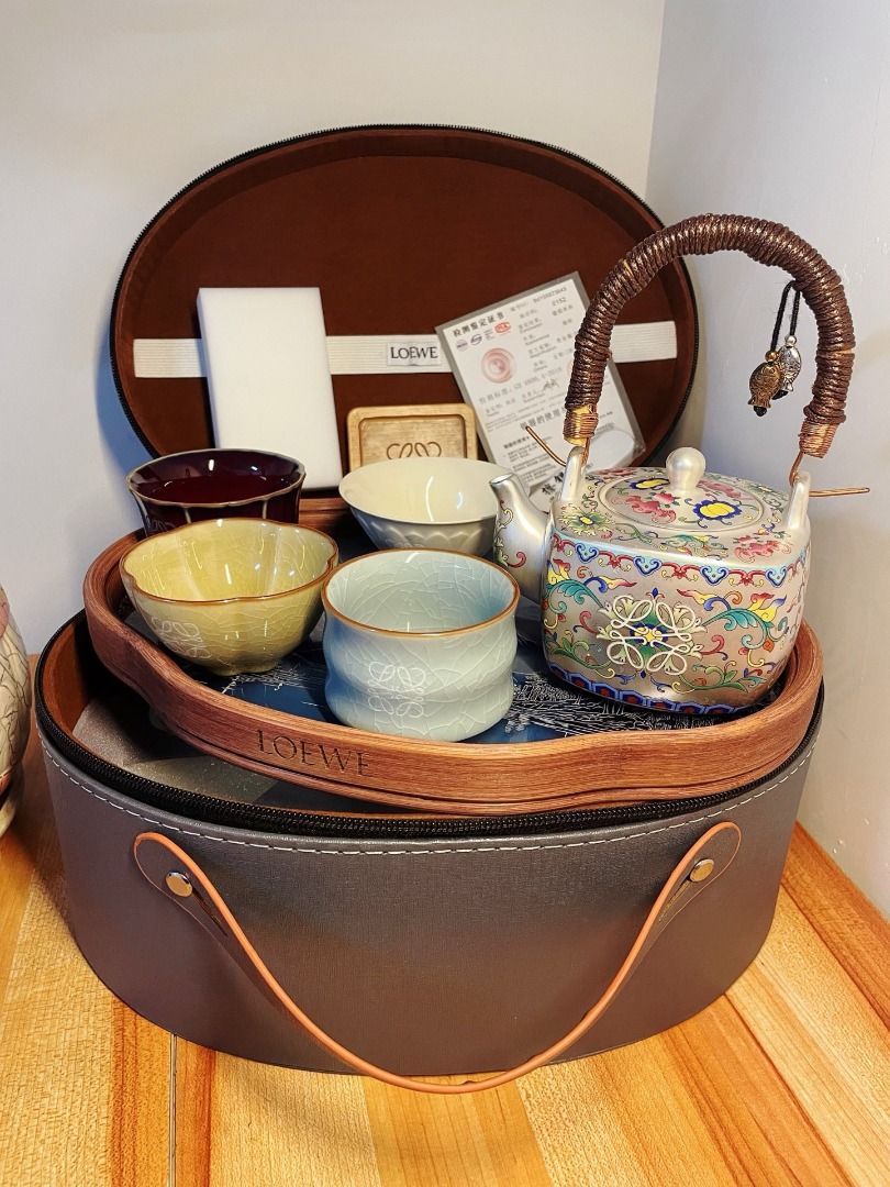 LOEWE Tea Set with Portable Case (Category: Coffee & Tea Tableware) located in Quezon City. Submitted by reifancova27621 (Listing ID 1467467525, Image 2). Description: - Brand new LOEWE ceramic tea set with a luxury grey round zip case - Includes 1 teapot with a braided handle and 5 uniquely glazed cups - Comes with a wooden tea coaster, certificate card, and cleaning sponge - Features stunning landscape artwork inside the case lid - Ideal for te