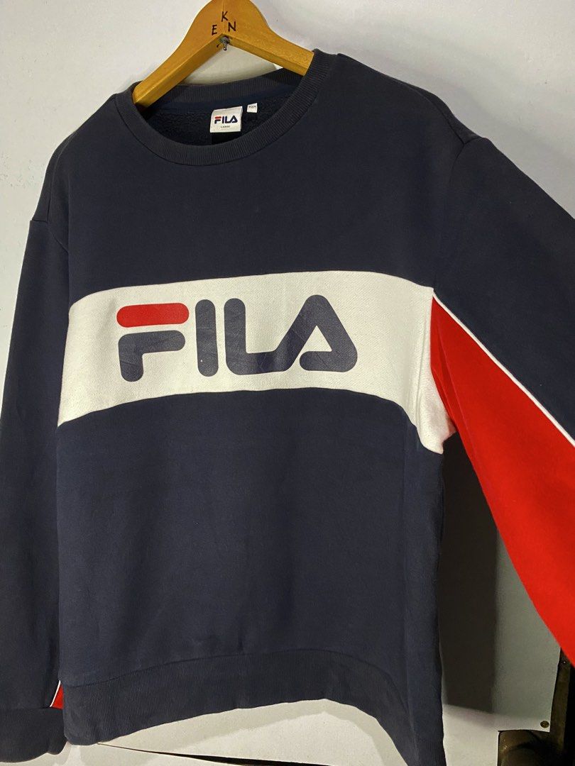 LONG SLEEVE (Category: Hoodies) located in Jaen. Submitted by oshimamark58418 (Listing ID 1467453994, Image 3). Description: - Brand: FILA - Style: Long sleeve sweatshirt / pullover with fleece lining - Size: Large (Regular Fit) - Color: Dark blue with white chest band and red sleeve accents - Condition: Good pre-loved condition (4/5) - Features iconic FILA logo across the chest.