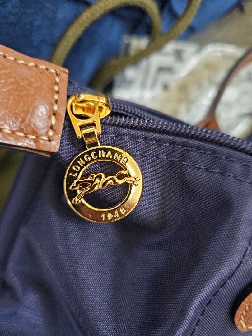 Longchamp Le Pliage Navy Blue Small Short Handle (Category: Luxury Bags & Wallets) located in Taguig. Submitted by rachelmarby (Listing ID 1467388160, Image 3). Description: -🎅🎄BRAND NEW and AUTHENTIC Longchamp Le Pliage handbag in classic navy blue - Durable foldable nylon body with brown leather handles and flap - Elegant gold-tone hardware featuring signature horse logo - comes with paper bag 🇫🇷 Made in France.