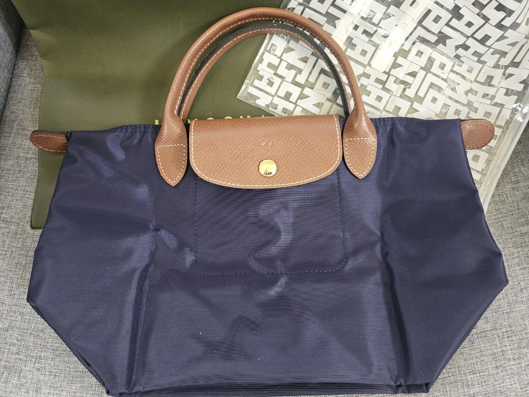 Longchamp Le Pliage Navy Blue Small Short Handle (Category: Luxury Bags & Wallets) located in Taguig. Submitted by rachelmarby (Listing ID 1467388160, Image 1). Description: -🎅🎄BRAND NEW and AUTHENTIC Longchamp Le Pliage handbag in classic navy blue - Durable foldable nylon body with brown leather handles and flap - Elegant gold-tone hardware featuring signature horse logo - comes with paper bag 🇫🇷 Made in France.