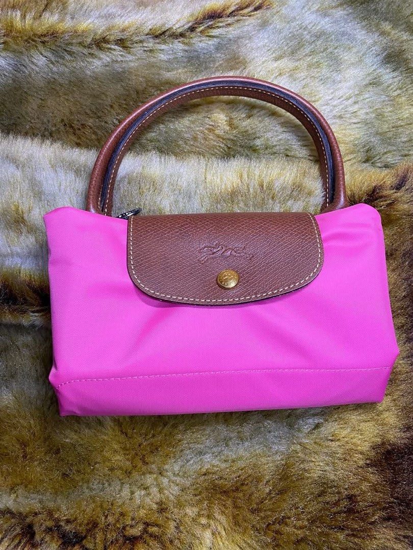 Longchamp Le Pliage Pink Nylon Short Handle Handbag (Category: Luxury Bags & Wallets) located in Manila. Submitted by iamangelica20 (Listing ID 1467452190, Image 1). Description: - Brand: Longchamp style foldable tote - Color: Bright pink nylon with brown leather trim - Hardware: Silver-tone horse medallion zipper pull & gold snap button - Carry style: Short handles for hand or arm wear - Features: Top zip closure, lightweight, and foldable desig