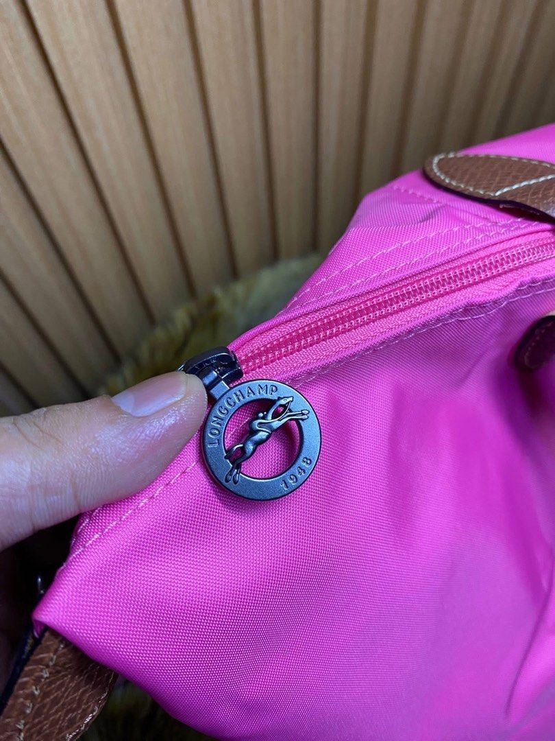 Longchamp Le Pliage Pink Nylon Short Handle Handbag (Category: Luxury Bags & Wallets) located in Manila. Submitted by iamangelica20 (Listing ID 1467452190, Image 3). Description: - Brand: Longchamp style foldable tote - Color: Bright pink nylon with brown leather trim - Hardware: Silver-tone horse medallion zipper pull & gold snap button - Carry style: Short handles for hand or arm wear - Features: Top zip closure, lightweight, and foldable desig