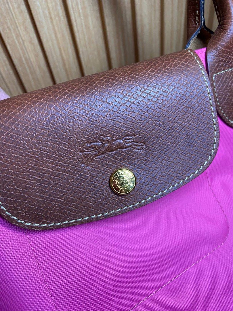 Longchamp Le Pliage Pink Nylon Short Handle Handbag (Category: Luxury Bags & Wallets) located in Manila. Submitted by iamangelica20 (Listing ID 1467452190, Image 2). Description: - Brand: Longchamp style foldable tote - Color: Bright pink nylon with brown leather trim - Hardware: Silver-tone horse medallion zipper pull & gold snap button - Carry style: Short handles for hand or arm wear - Features: Top zip closure, lightweight, and foldable desig
