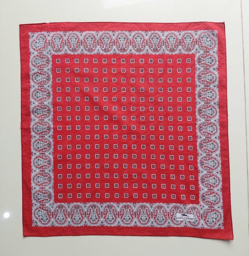 Longchamp Paris Red Paisley Handkerchief (Category: Handkerchief & Pocket Squares) located in Lapu Lapu. Submitted by agnesapm_29813 (Listing ID 1467508588, Image 1). Description: - Brand: Longchamp Paris - Material: 100% Cotton, Made in Italy - Design: Classic paisley borders with repeating small square patterns in the center - Measurements: 16.5 x 16.5 inches - Details: Includes original Longchamp label and 'Made in Italy' tag - Styling: Perfec