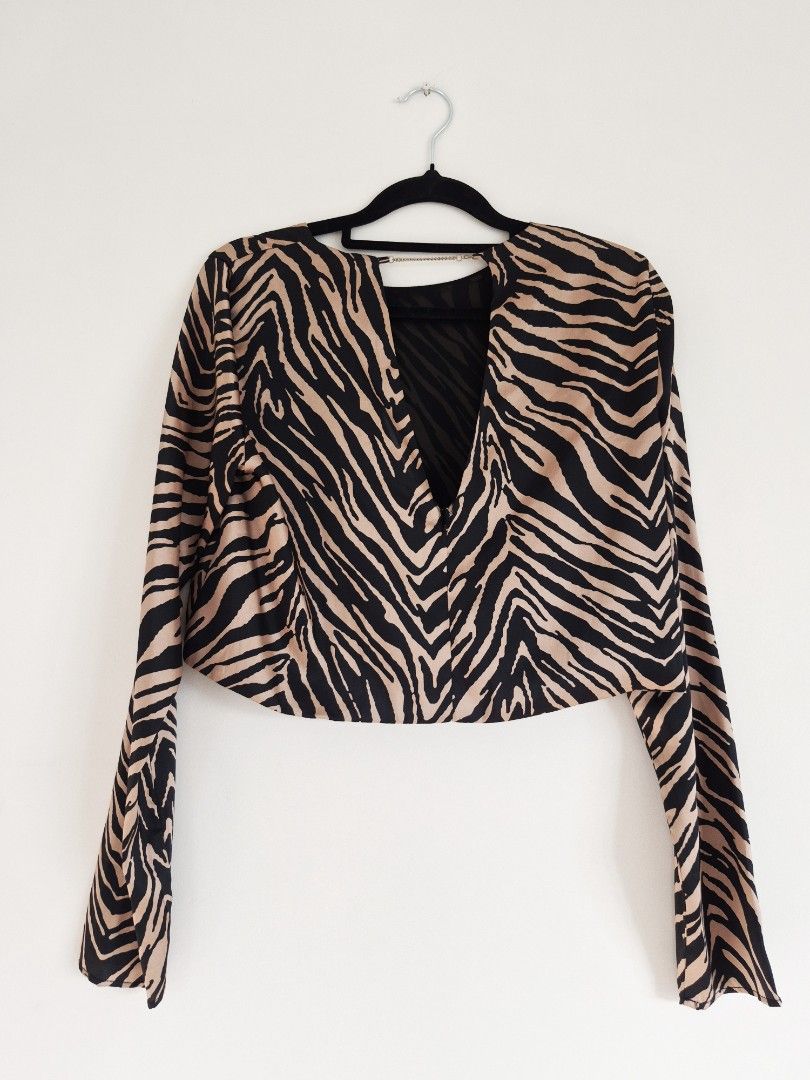 Longsleeves semi cropped zebra print top (Category: Longsleeves) located in Manila. Submitted by unknowncloset (Listing ID 1467449565, Image 3). Description: - Bold black and tan zebra print pattern - Trendy long sleeves and short cropped front hem - Unique open back design with a chic metal chain across the neckline - Stylish longer draped back - Lightweight fabric, ideal for night outs and parties.
