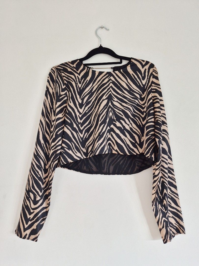 Longsleeves semi cropped zebra print top (Category: Longsleeves) located in Manila. Submitted by unknowncloset (Listing ID 1467449565, Image 1). Description: - Bold black and tan zebra print pattern - Trendy long sleeves and short cropped front hem - Unique open back design with a chic metal chain across the neckline - Stylish longer draped back - Lightweight fabric, ideal for night outs and parties.