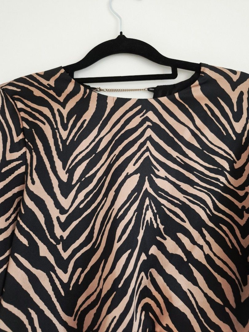 Longsleeves semi cropped zebra print top (Category: Longsleeves) located in Manila. Submitted by unknowncloset (Listing ID 1467449565, Image 2). Description: - Bold black and tan zebra print pattern - Trendy long sleeves and short cropped front hem - Unique open back design with a chic metal chain across the neckline - Stylish longer draped back - Lightweight fabric, ideal for night outs and parties.