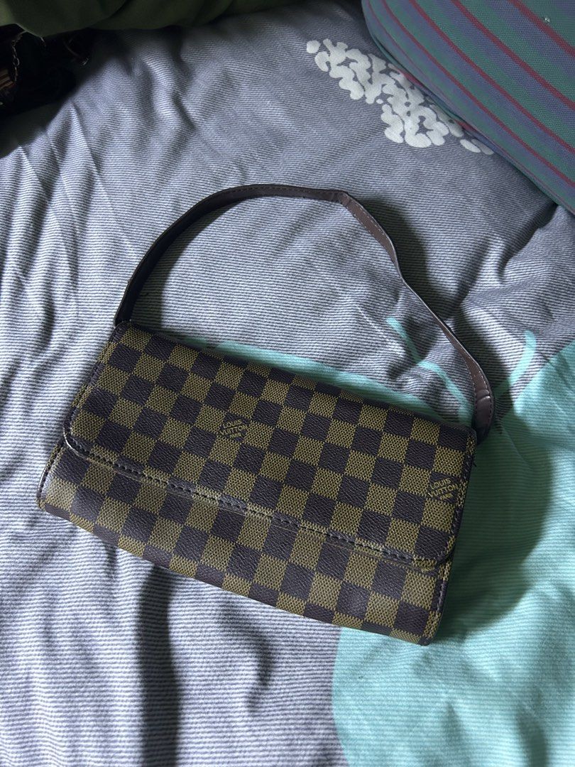 Louis Vuitton Damier Ebene Canvas Shoulder Bag (Category: Shoulder Bags) located in Quezon City. Submitted by thriftxgoods (Listing ID 1467437143, Image 1). Description: - Brown checkerboard canvas design with a dark brown shoulder strap - Secure flap closure with a magnetic snap button - Fabric-lined interior featuring a convenient zippered center divider - Additional inner zipper pocket for secure storage - Finished with an interior leather tag