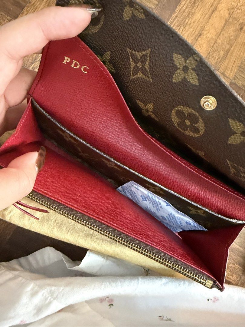 Louis Vuitton Monogram Sarah Wallet with Hot Stamp PDC (Category: Luxury Bags & Wallets) located in Manila. Submitted by paupreloveditems88 (Listing ID 1467393082, Image 3). Description: - Authentic Monogram Canvas Exterior - Striking Red Interior Lining with Gold-Tone Hardware - Features: Multiple card slots, zipped coin pocket, and open compartments - Personalized: Hot-stamped initials "PDC" in gold on the inside flap - Inclusion: Comes with or