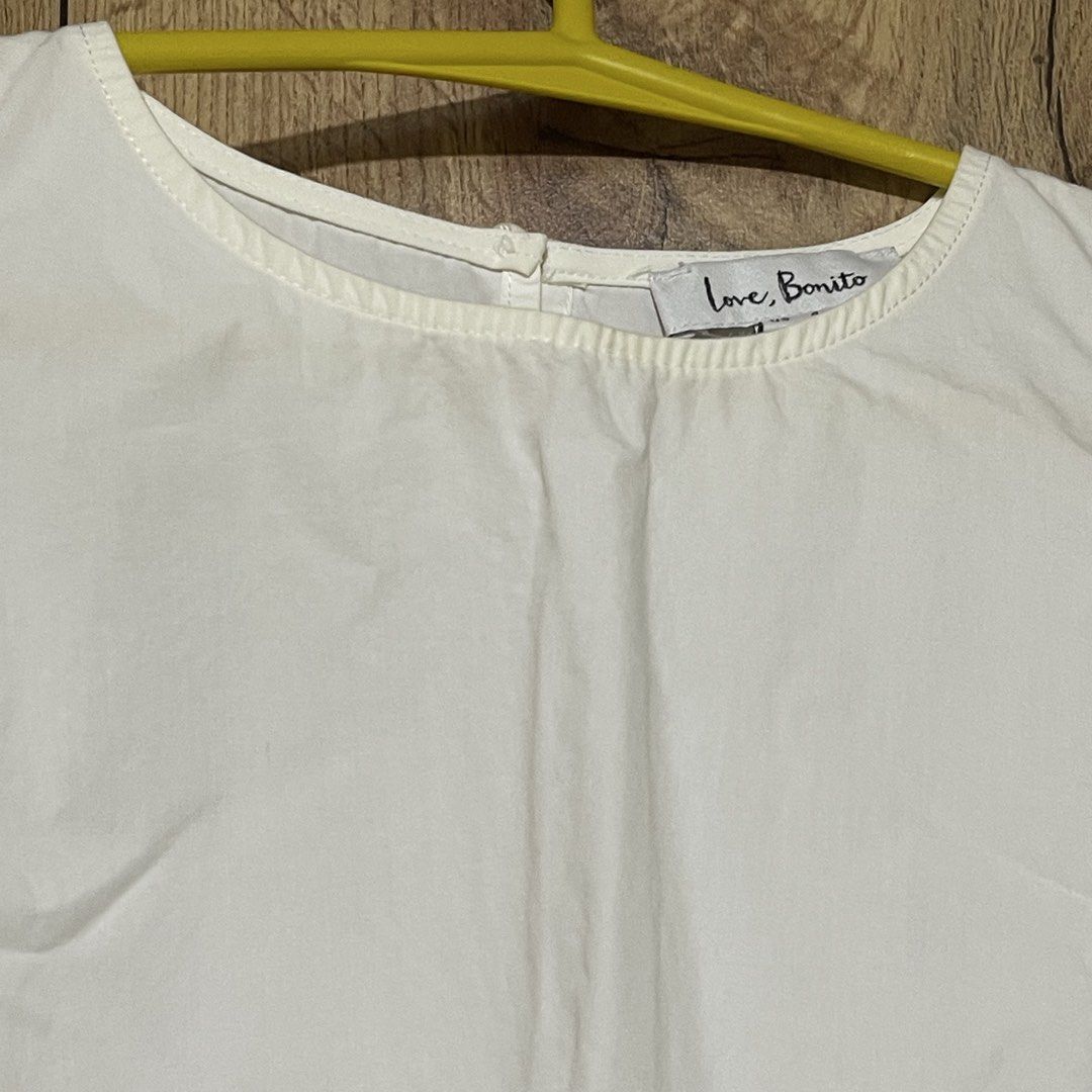 Love Bonito White Cold Shoulder Blouse Size S (Category: Blouses) located in Manila. Submitted by cluttercleanwme (Listing ID 1467584320, Image 2). Description: - Brand: Love Bonito - Color: Crisp white - Size: S (UK 8 / US 4, tag attached) but fits until medium since it’s flowy - Design: Cold shoulder with crew neckline and back button fastening - Sleeves: Long bishop sleeves with gathered cuffs - Material: High-quality cotton - Versatility: Per