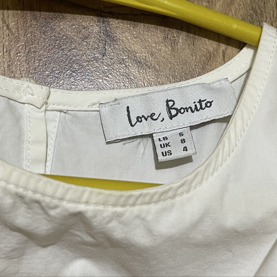 Love Bonito White Cold Shoulder Blouse Size S (Category: Blouses) located in Manila. Submitted by cluttercleanwme (Listing ID 1467584320, Image 3). Description: - Brand: Love Bonito - Color: Crisp white - Size: S (UK 8 / US 4, tag attached) but fits until medium since it’s flowy - Design: Cold shoulder with crew neckline and back button fastening - Sleeves: Long bishop sleeves with gathered cuffs - Material: High-quality cotton - Versatility: Per