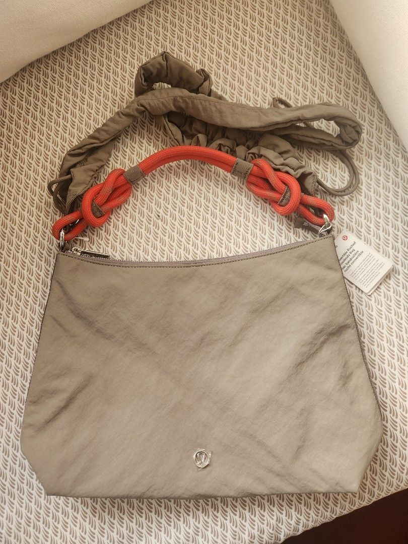 Lululemon Convertible Ruched Crossbody Bag (Category: Cross-body Bags) located in Makati City. Submitted by mikamix (Listing ID 1467601376, Image 1). Description: - Brand: Lululemon - Style: Convertible ruched crossbody bag - Color: Muted green with a bright orange knotted rope strap - Hardware: Silver-tone with top zipper closure - Interior: Grey fabric lining with convenient zip and slip pockets - Condition: Brand new, never used, with original