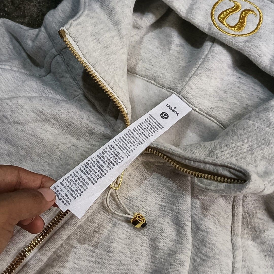 Lululemon Define Jacket Grey Gold Logo Size 4 (Category: Coats, Jackets and Outerwear) located in Caloocan City. Submitted by gemfinder669 (Listing ID 1467471608, Image 3). Description: - Brand: Lululemon - Style: Grey marled cotton zip-up hoodie - Size: 4 (170/80A) - Details: Shiny gold zipper, embroidered logo on hood, drawstring adjustments with gold hardware - Features: Built-in thumbholes on long cuffs, front pockets, structured fit - Condit