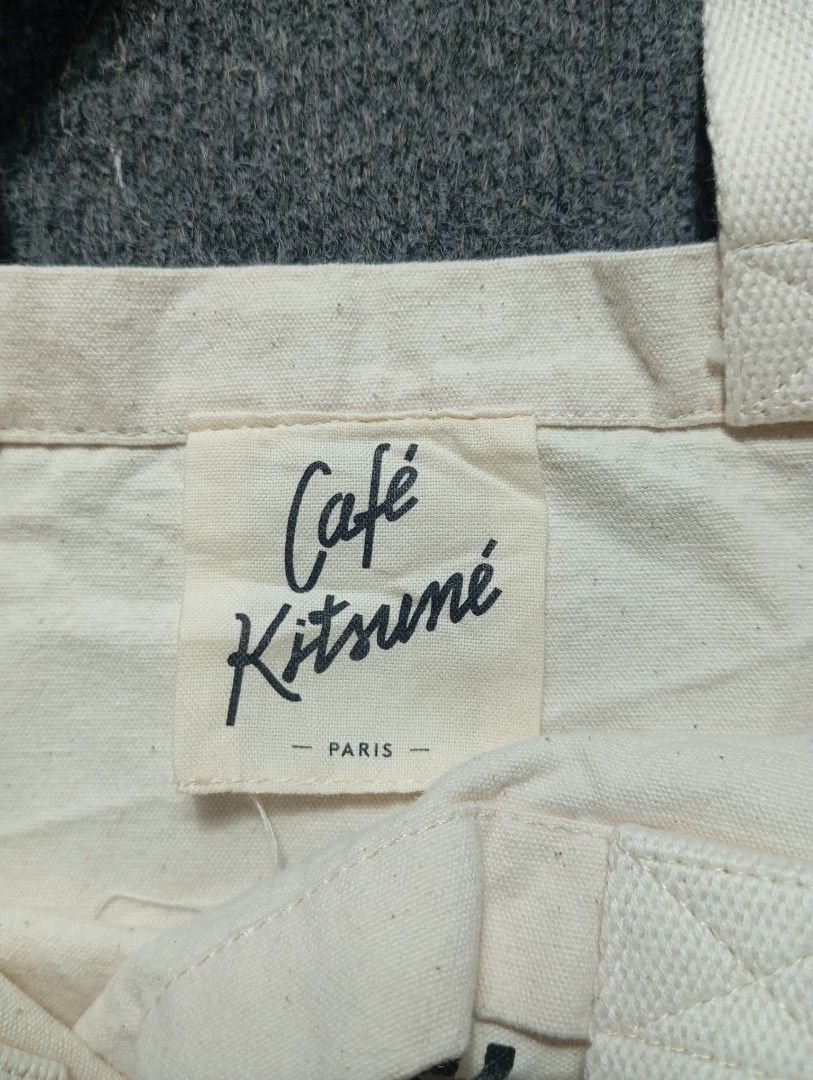 Maison Kitsuné Paris Canvas Tote Bag (Category: Tote Bags) located in Ligao. Submitted by merjudioma64633 (Listing ID 1467365949, Image 2). Description: - Brand: Café Kitsuné - Color: Off-white - Material: Durable canvas - Design: Signature script logo on front, open top with double top handles - Interior: Includes brand label tag and product care tag - Origin: Made in Korea - Size: Standard everyday size for daily essentials - Condition: .