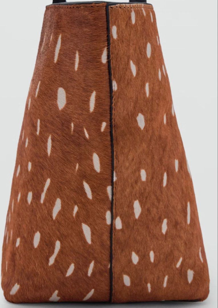 MANGO Deer Print Cowhide Shoulder Bag (Category: Shoulder Bags) located in Angeles City. Submitted by adeclutters__ (Listing ID 1467532106, Image 2). Description: - Brand: MANGO - Design: Brown and white deer print cowhide finish with matching black leather trim - Straps: Slim black leather shoulder straps - Interior: Dark lining with MANGO logo patch and a handy zip pocket - Style: Chic animal print accessory, perfect for daily use or special oc