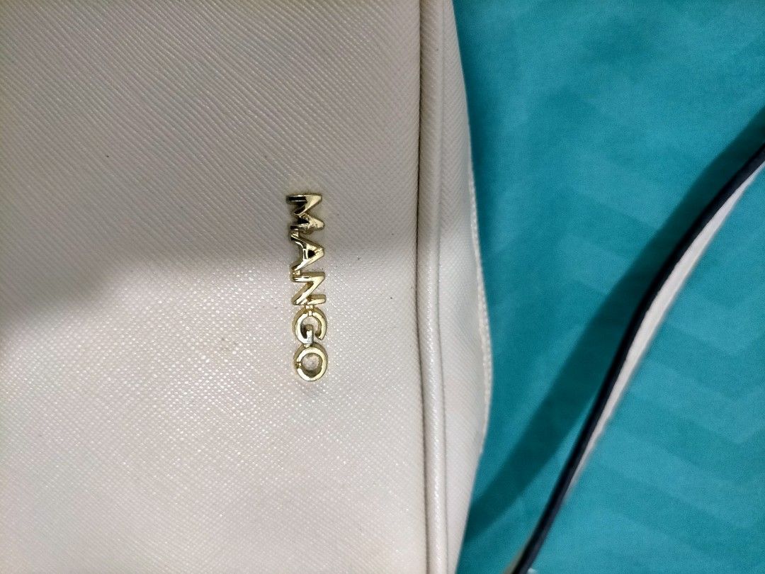 Mango off White Crossbody Bag (Category: Cross-body Bags) located in Iba. Submitted by pautheamitch (Listing ID 1467485939, Image 3). Description: - Brand: Mango, bought from the states - Color: off White with gold hardware lettering - Style: Compact crossbody bag - Closure: Top zipper - Strap: Adjustable - Interior: Black fabric lining with brand tag and original product label tag.