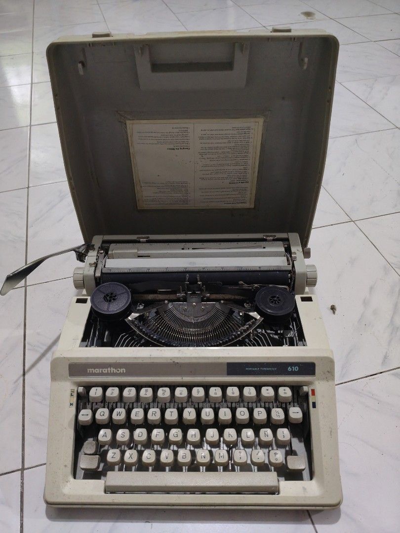 Marathon 610 Portable Typewriter with Hard Cover Case (Category: Office & Business Technology) located in Taguig. Submitted by akosimilo2026 (Listing ID 1467384552, Image 1). Description: - Model: Marathon 610 portable typewriter - Color: Classic beige body with black keys - Layout: Standard QWERTY keyboard - Accessories: Includes original carrying case lid with instruction sheet glued inside - Condition: Shows dust and dirt from storage, great f