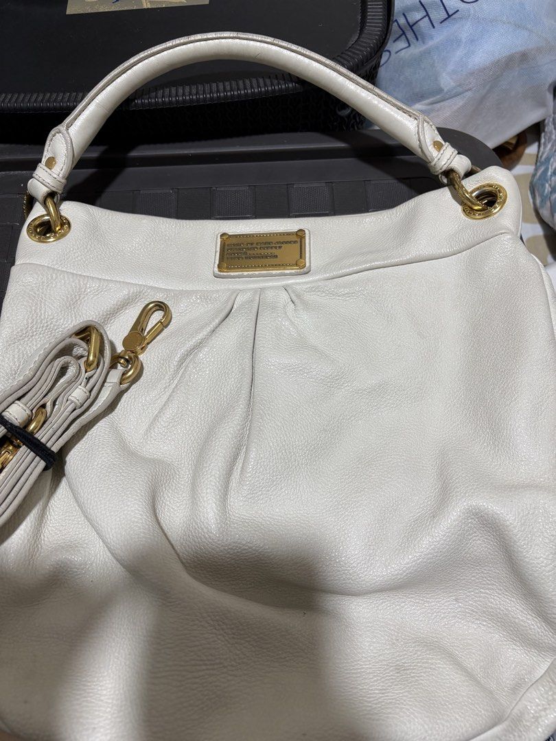 Marc by Marc Jacobs White Leather Shoulder Bag (Category: Luxury Bags & Wallets) located in Pasig City. Submitted by anenri (Listing ID 1467410051, Image 2). Description: - Brand: Marc by Marc Jacobs - Material: White textured leather - Hardware: Gold-tone with front metal logo plaque - Straps: Top handle plus an adjustable and detachable shoulder strap - Closure: Secure magnetic top snap - Interior: Monogram fabric lining with a convenient zip p