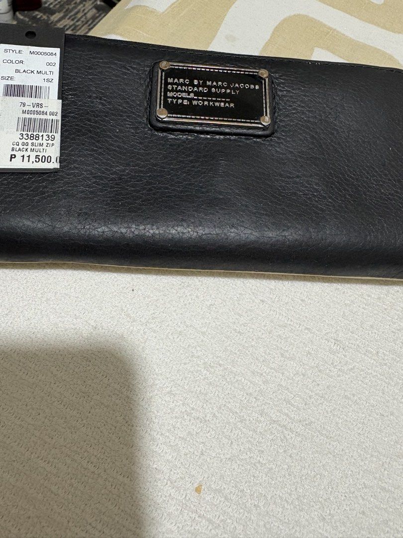 Marc Jacobs M0005084 Black Multi Zip Wallet (Category: Wallets & Card holders) located in Pasig City. Submitted by anenri (Listing ID 1467430694, Image 1). Description: Marc Jacobs zip around wallet in black multi colorway. Style code M0005084. Inside has multiple card slots, zip coin pocket, and black-and-white patterned lining. Tag still attached showing color 002. Smooth leather exterior construction with silver-tone hardware..