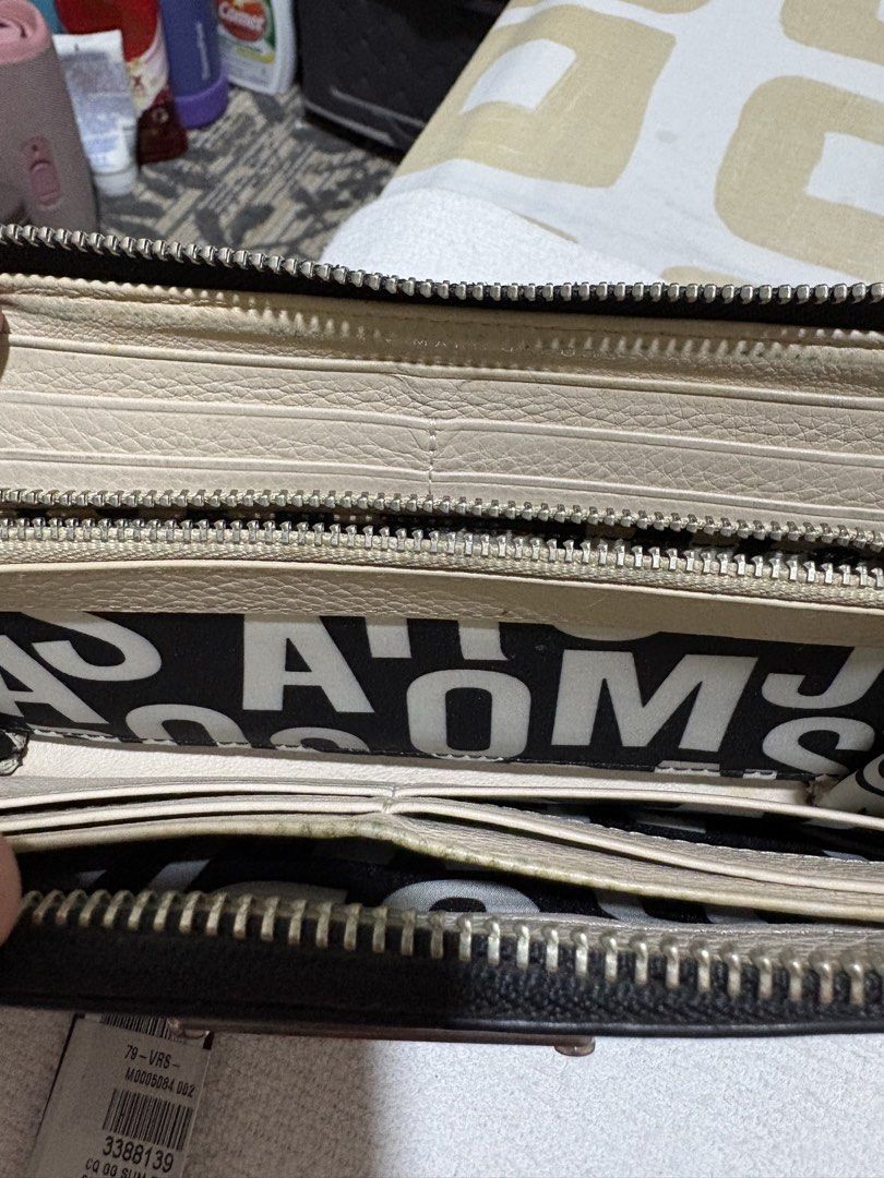 Marc Jacobs M0005084 Black Multi Zip Wallet (Category: Wallets & Card holders) located in Pasig City. Submitted by anenri (Listing ID 1467430694, Image 3). Description: Marc Jacobs zip around wallet in black multi colorway. Style code M0005084. Inside has multiple card slots, zip coin pocket, and black-and-white patterned lining. Tag still attached showing color 002. Smooth leather exterior construction with silver-tone hardware..