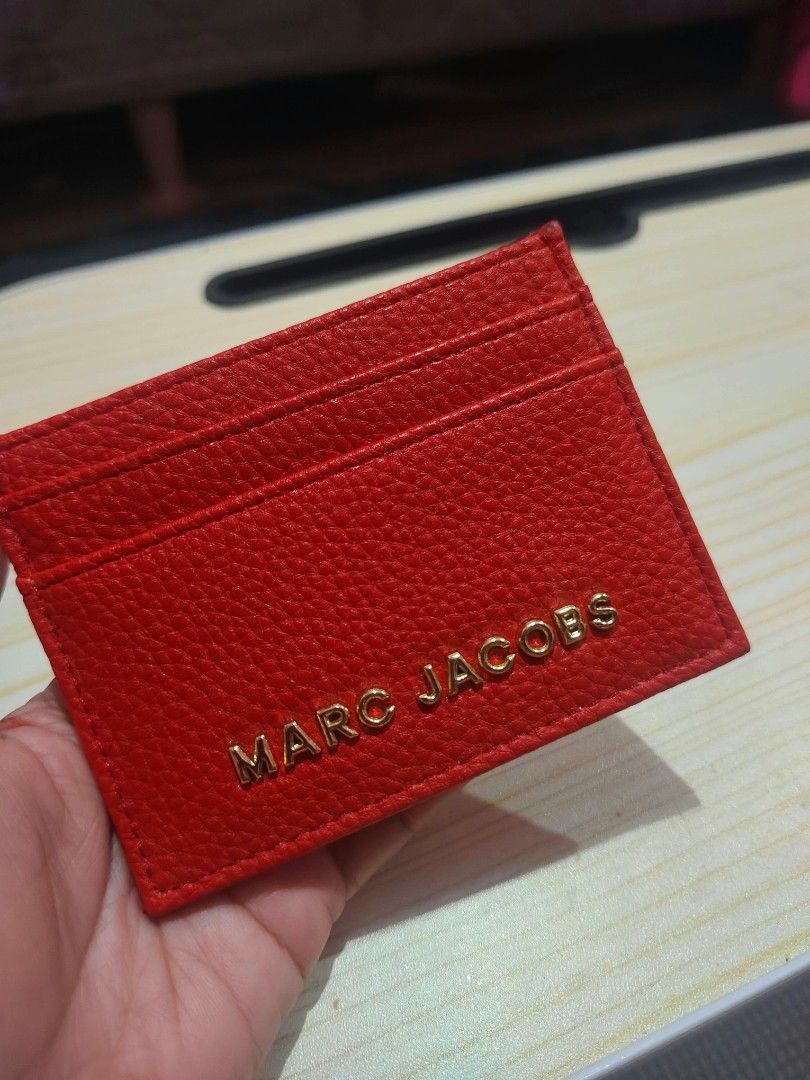 Marc Jacobs Red Leather Card Holder (Category: Wallets & Card holders) located in Cavite. Submitted by mahthriftshop (Listing ID 1467382594, Image 2). Description: - Marc Jacobs card holder in bright red leather - Features a clear gold hardware logo on the front - Multiple card slots on both sides for easy organization - Slim, compact design fits easily in any bag - Clean stitching all around - DM for fast transactions / shipping details.