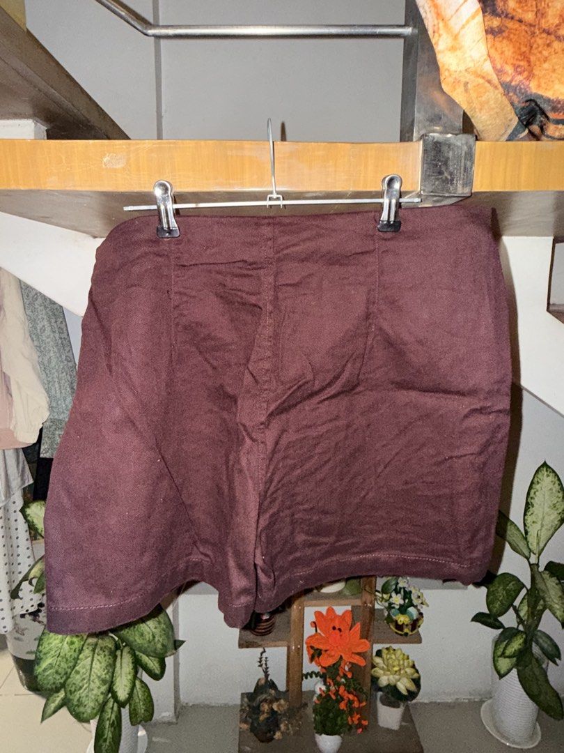 Maroon denim skort with side tie (Category: Skirts) located in Manila. Submitted by clalala.fire (Listing ID 1467526925, Image 2). Description: - Color: Deep maroon (rich autumn shade) - Design: Wrap style with a chic side tie on the right hip and structured back paneling for a flattering fit - Fabric: Textured, linen-look material with clean hem stitching - Styling: Perfect to pair with basic tees or blouses for casual days out - Condition: Bran