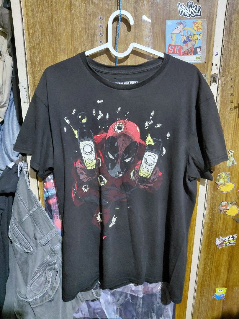 Marvel Deadpool Graphic Black T-shirt Medium (Category: Tshirts & Polo Shirts ) located in Imus. Submitted by frootiloots4103 (Listing ID 1467378459, Image 1). Description: - Color: Black - Design: Bold front graphic print of Deadpool and guns - Size: M (Measures approx. 21" x 29") - Material: Cotton blend - Condition: Good overall, with a small hole near the neckline label area OPEN FOR NEGO (best if aspack) 📍 Imus, Cavite 4103 Can do meetups w