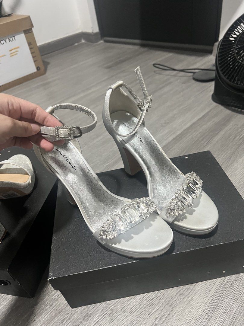 Matthews Silver Rhinestone Strappy High Heels (Category: Heels) located in Makati City. Submitted by errrkey (Listing ID 1467503520, Image 2). Description: - Brand: Matthews - Color: Silver - Material: Satin finish - Heel Type: Chunky heel with platform sole - Embellishment: Front strap covered in large sparkling crystals - Closure: Ankle strap with adjustable buckle - Inclusions: Original black box included - Size: 37 Price is negotiable.