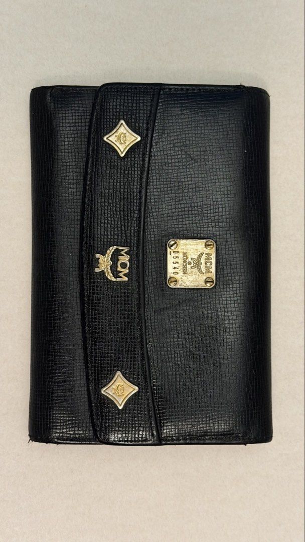 MCM Black Leather München Wallet with Gold Hardware (Category: Luxury Bags & Wallets) located in Tarlac. Submitted by jzennoroyy-32960 (Listing ID 1467372986, Image 2). Description: LP No haggling already just need to clear out to make space for storage - 100% Authentic MCM trifold wallet from München - Crafted from textured black leather with gold-toned logo plaques and diamond studs - Secure front flap closure and convenient external zippered c