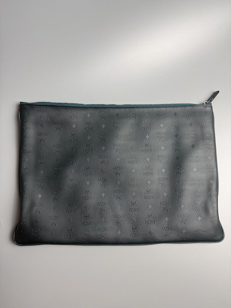 MCM Visetos Studded Leather Clutch (Category: Luxury Bags & Wallets) located in Manila. Submitted by limsanity03 (Listing ID 1467490234, Image 2). Description: Dark green leather clutch from MCM. One side covered in pyramid studs, reverse side features debossed MCM monogram print. Secure zip closure with gunmetal hardware. Textured fabric lining inside. Made in Korea. Style code MYZ5AVH07GV001..