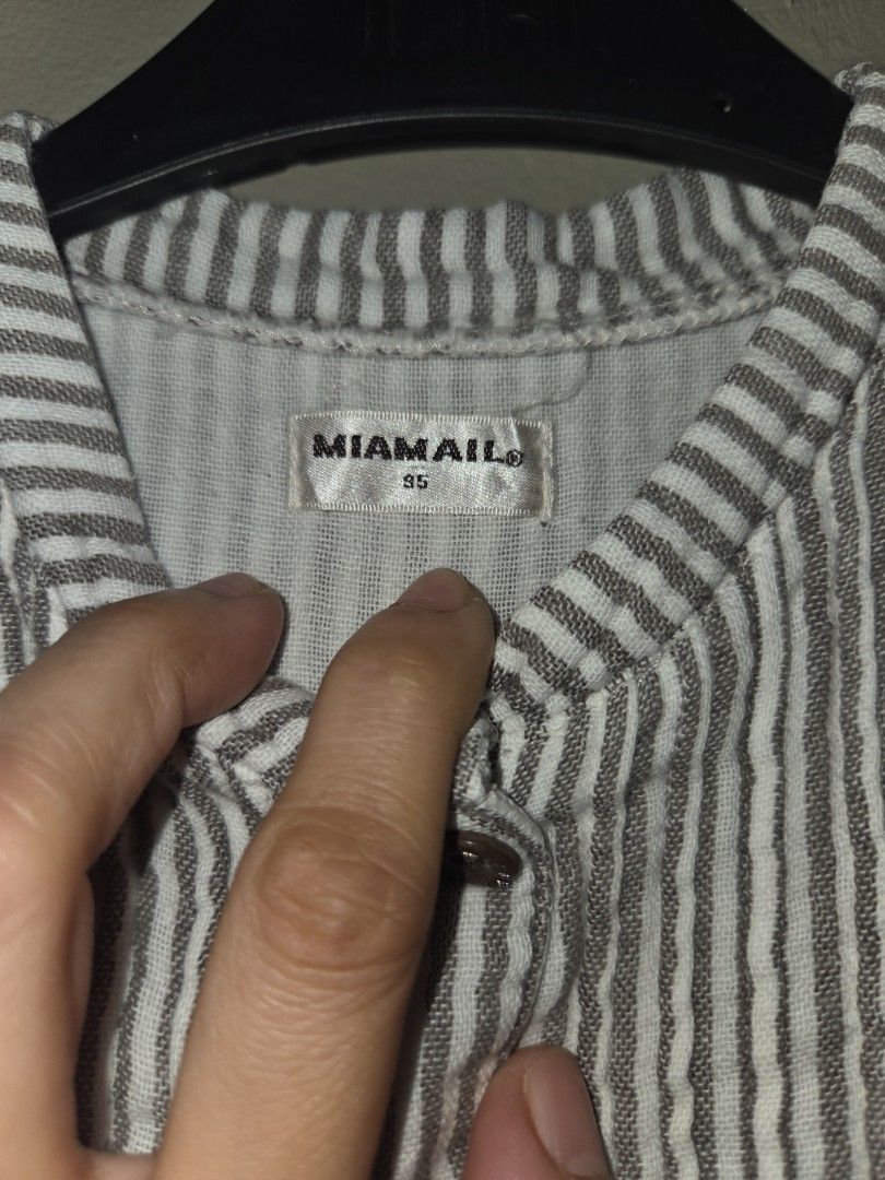 Miamail Striped Button-Front Long Sleeve Blouse Size 95 (Category: Babies & Kids Fashion) located in Quezon City. Submitted by klarebear15 (Listing ID 1467585789, Image 2). Description: - Brand: Miamail - Size: 95 - Design: Gray and white stripes with button-front closure and brown buttons - Special Features: Decorative vertical embroidered panel near the hem and ruffled cuffs - Neckline: Round neckline.
