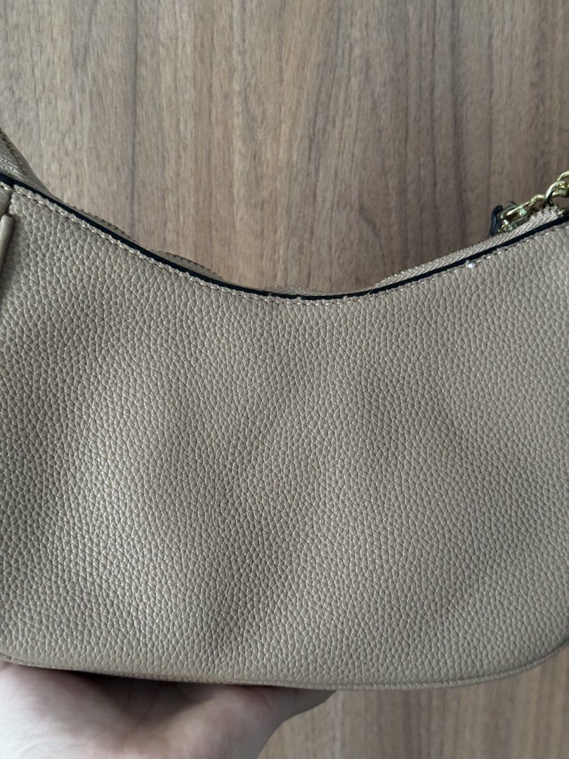 Michael Kors Beige Shoulder Bag (Category: Shoulder Bags) located in Bacoor. Submitted by nicafindssince2022 (Listing ID 1467410393, Image 3). Description: - Michael Kors shoulder bag - Color: Classic Beige in luxurious pebble leather - Hardware: Gold-tone chain strap (still wrapped in protective foam) - Closure: Zip top with leather pull tabs - Interior: Signature MK logo fabric lining with 1 zip pocket and 1 slip pocket - Style: Chic and compac