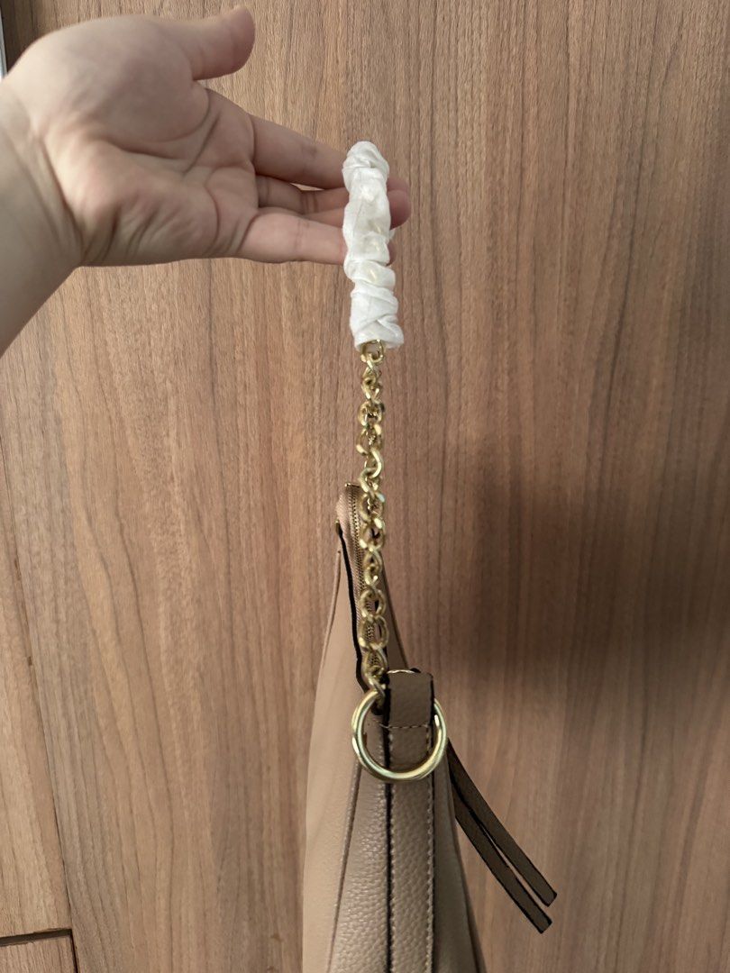 Michael Kors Beige Shoulder Bag (Category: Shoulder Bags) located in Bacoor. Submitted by nicafindssince2022 (Listing ID 1467410393, Image 2). Description: - Michael Kors shoulder bag - Color: Classic Beige in luxurious pebble leather - Hardware: Gold-tone chain strap (still wrapped in protective foam) - Closure: Zip top with leather pull tabs - Interior: Signature MK logo fabric lining with 1 zip pocket and 1 slip pocket - Style: Chic and compac