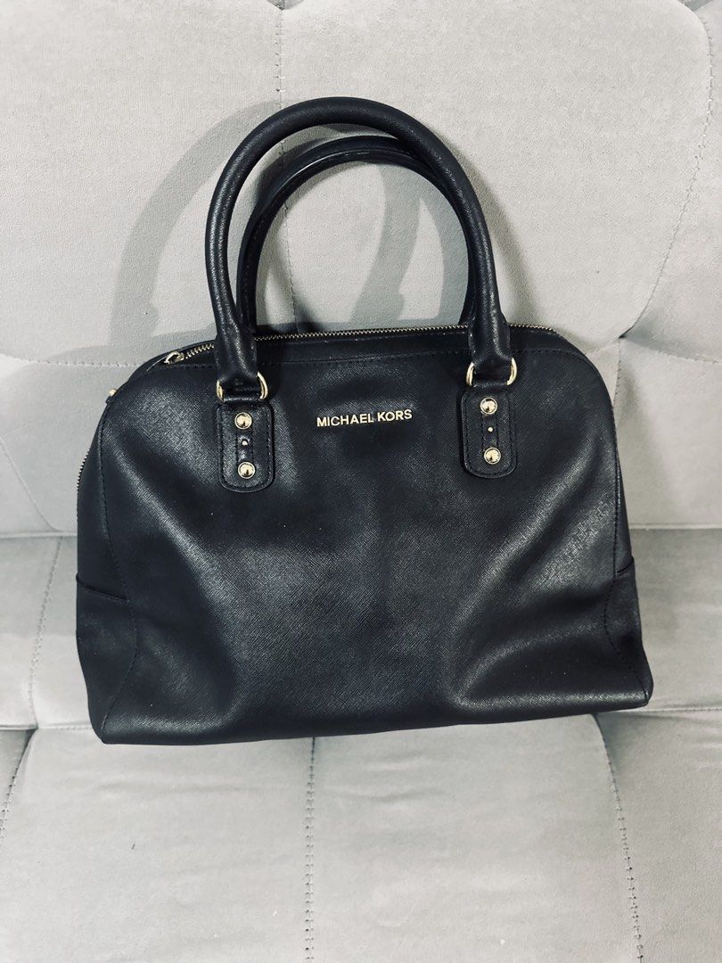 Michael Kors Black Satchel Handbag (Category: Luxury Bags & Wallets) located in Tarlac. Submitted by via_banana (Listing ID 1467426744, Image 1). Description: - Brand: Michael Kors - Color: Black leather with elegant gold hardware - Style: Structured dome satchel with double rolled handles - Closure: Secure top zip closure - Interior: Black MK logo fabric lining with zipper and slip pockets - Extra: Bottom metal protective feet for durability - C