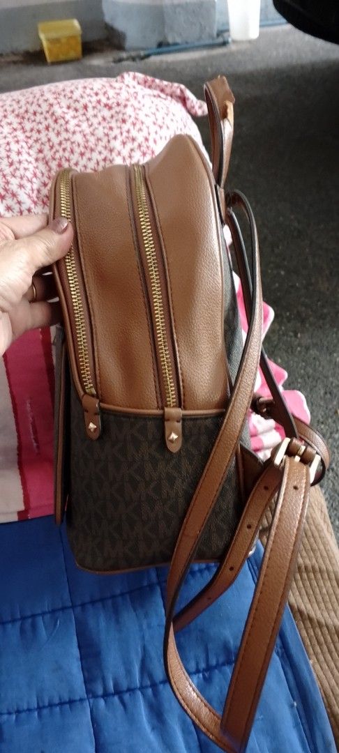 Michael Kors Brown MK Monogram Backpack (Category: Backpacks) located in Caloocan City. Submitted by nobleflower_4c42cc (Listing ID 1467412570, Image 2). Description: - Brand: Michael Kors - Design: Classic brown MK monogram print with tan leather trim and gold-tone hardware - Compartments: Secure double zip main closure and convenient front zippered pocket - Carry Options: Adjustable shoulder straps and top carry handle - Condition: Good overall