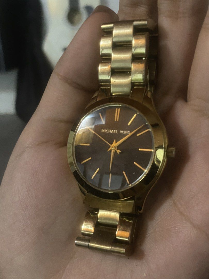 Michael Kors MK-3478 Gold Watch (Category: Women's Watches) located in Manila. Submitted by bravecrystal_574710 (Listing ID 1467563297, Image 1). Description: - Brand: Michael Kors - Model: MK-3478 - Color: Gold with a striking dark brown dial, gold hands, and hour markers - Strap: Classic link bracelet with a secure fold-over clasp - Water Resistance: Up to 10 atmospheres (100 meters) - Condition: Normal signs of wear on the metal surface, overa