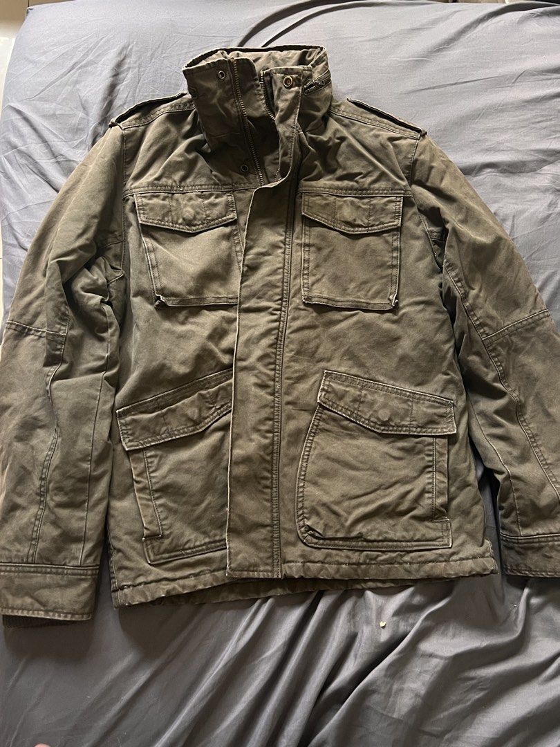 Military Style Olive Green Field Jacket (Category: Coats, Jackets and Outerwear) located in Manila. Submitted by vandetoria (Listing ID 1467386098, Image 2). Description: - Color: Olive green with a rugged washed finish - Closure: Full zip with front snap buttons - Pockets: Four large buttoned cargo pockets (chest and lower front) - Details: High stand-up collar and shoulder epaulets - Fit/Style: Great casual layer for cooler weather.