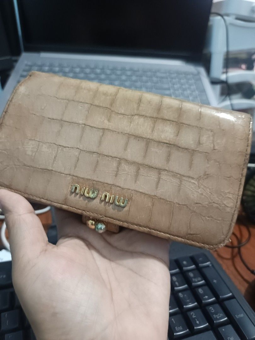 Miu Miu Crocodile Embossed Leather Wallet (Category: Wallets & Card holders) located in Pagsanjan. Submitted by enci25 (Listing ID 1467377747, Image 1). Description: - Brand: Miu Miu - Material: Tan crocodile-embossed leather with light pink interior lining - Hardware: Gold-tone metal lettering and accents - Compartments: Multiple card slots, cash compartments, and zippered coin pocket - Special Feature: Top kiss-lock coin purse section - Conditi