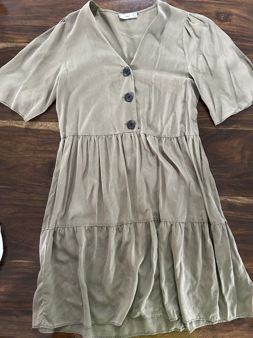 MNG Olive Green Button-Front Tiered Dress (Category: Dresses) located in Muntinlupa City. Submitted by manikascloset (Listing ID 1467395337, Image 1). Description: - Brand: MNG (Mango) - Size: Medium (EUR M / USA 6) - Color: Olive Green - Design: V-neckline with 3 dark front buttons, short puff sleeves, layered tiered skirt - Material: Lightweight fabric with a soft finish - Condition: great / Pre-loved - Mode of Payment: BPI/Metrobank - Shipping